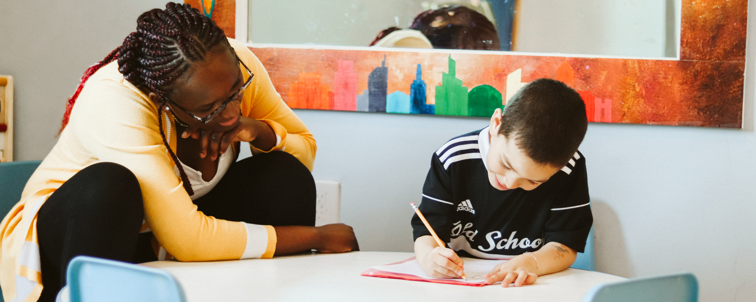 College student tutoring child at table