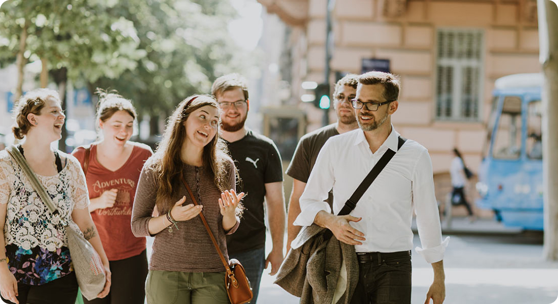 students walking down a street in the Balkans with a professor